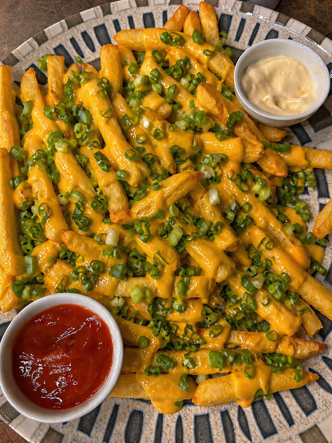 Papas fritas con cheddar y verdeo